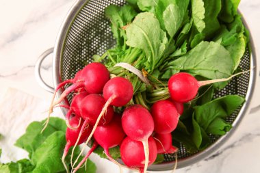 Beyaz mermer arka planda taze turplu Colander