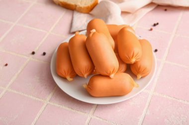 Pembe fayanslı lezzetli kaynamış sosisler.