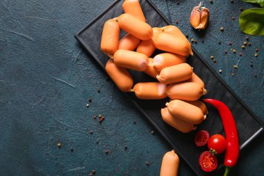 Lezzetli kaynamış sosis ve koyu arkaplanda kırmızı biber.