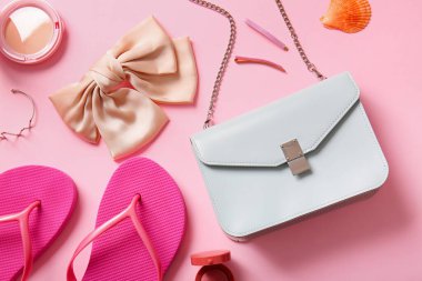 Pembe arka planda şık çanta ve farklı aksesuarlar.