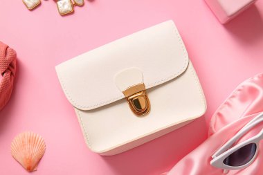 Pembe arka planda şık çanta ve farklı aksesuarlar.