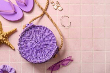 Pembe karo arka planda şık çanta ve farklı aksesuarlar.