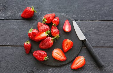 Siyah ahşap zemin üzerinde taze çilek olan tahta.