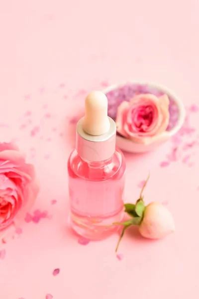 Butelka Olejku Kosmetycznego Ekstraktem Róży Kwiatami Różowym Tle — Zdjęcie stockowe