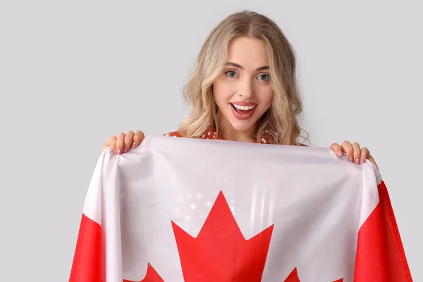 浅色背景的拿着加拿大国旗的年轻女子 — 图库照片