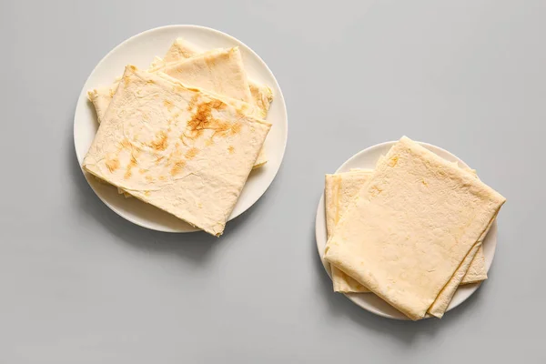 Stock image Plates with fresh thin lavash on grey background