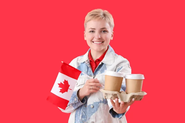 Junge Frau Mit Kanadischer Flagge Und Kaffeetassen Auf Rotem Hintergrund — Stockfoto