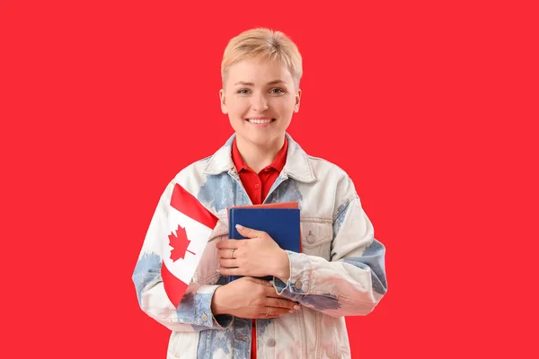 Junge Frau Mit Kanadischer Flagge Und Büchern Auf Rotem Hintergrund — Stockfoto