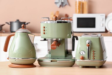 Elektrik ısıtıcısı, modern kahve makinesi ve ekmek kızartma makinesi mutfaktaki ahşap masada.