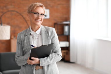 Ofisinde not tahtası olan olgun psikolog.