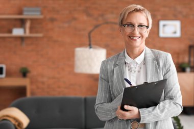 Ofisinde not tahtası olan olgun psikolog.