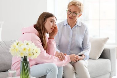 Ofiste ağlayan bir hastayla çalışan olgun bir psikolog.