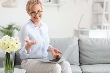 Ofiste dizüstü bilgisayarla çalışan olgun bir psikolog.