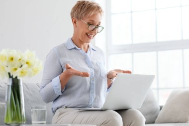 Ofiste dizüstü bilgisayarla çalışan olgun bir psikolog.