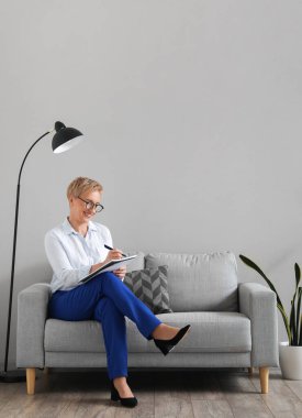 Olgun psikolog ofiste defterle çalışıyor.