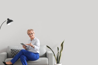 Ofiste tablet bilgisayarla çalışan olgun psikolog.