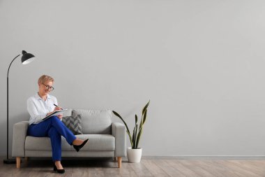 Olgun psikolog ofiste defterle çalışıyor.