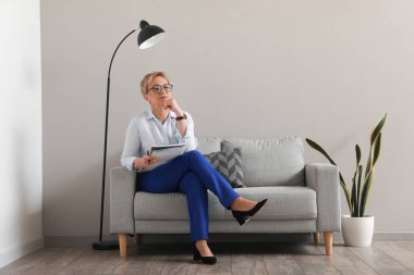 Olgun psikolog ofiste defterle çalışıyor.