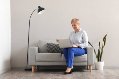 Ofiste dizüstü bilgisayarla çalışan olgun bir psikolog.