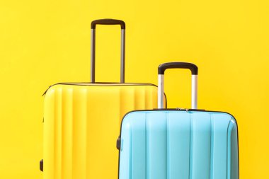 Sarı arka planda büyük bavullar, yakın plan.