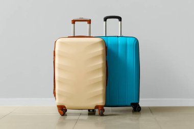 Büyük bavullar gri duvarın yanında.