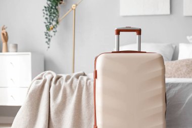 Yatağın yanındaki büyük bavul.