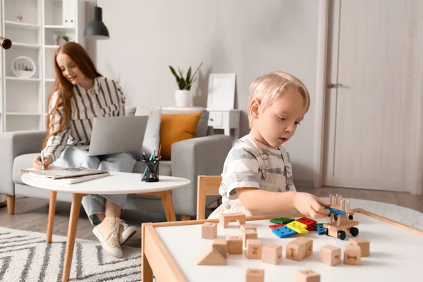 Cute Little Boy Playing Wooden Toys While His Mother Working — Stock Photo, Image
