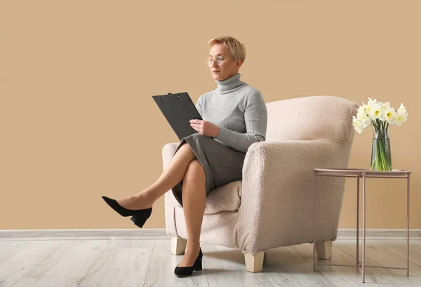 Mature Psychologist Working Clipboard Armchair Beige Wall — Stock Photo, Image