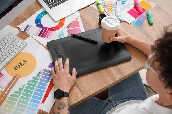 Ofiste çalışan bir fincan kahveli erkek grafik tasarımcısı, yakın plan.