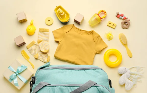 浅黄背景的婴儿服装 玩具及配件的成分 — 图库照片
