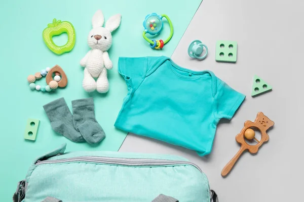 绿松石背景的婴儿服装和玩具的成分 — 图库照片