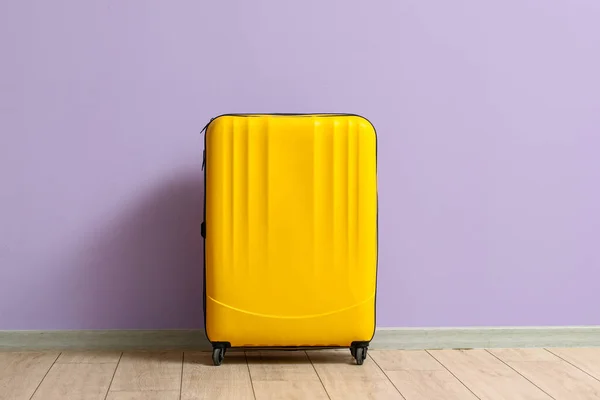 ライラック壁の近くの黄色のスーツケース — ストック写真