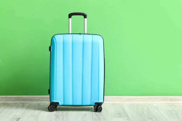 緑の壁の近くの青いスーツケース — ストック写真