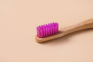 Kahverengi arka planda mor bambu diş fırçası.