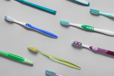 Gri arkaplanda birçok plastik diş fırçası
