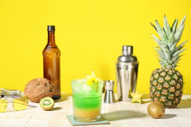 Sarı duvarın yanındaki fayans masasında taze yaz kokteyli.