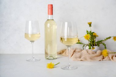 Beyaz masada bir şişe karahindiba şarabı.