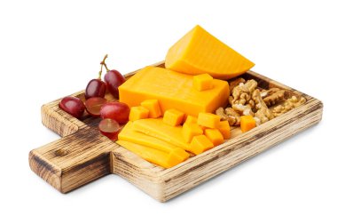 Lezzetli çedar peynirli ahşap tahta, beyaz arka planda üzüm ve fındık.