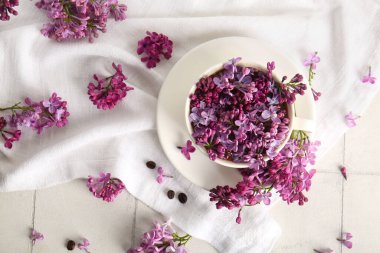 Üzerinde güzel leylak çiçekleri ve peçeteler olan kompozisyon.