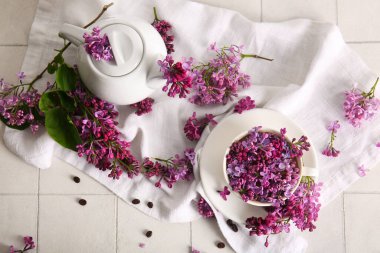 Çay takımlı kompozisyon ve açık fayanslı güzel leylak çiçekleri