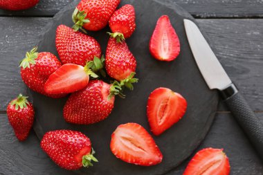 Siyah ahşap zemin üzerinde taze çilek olan tahta.