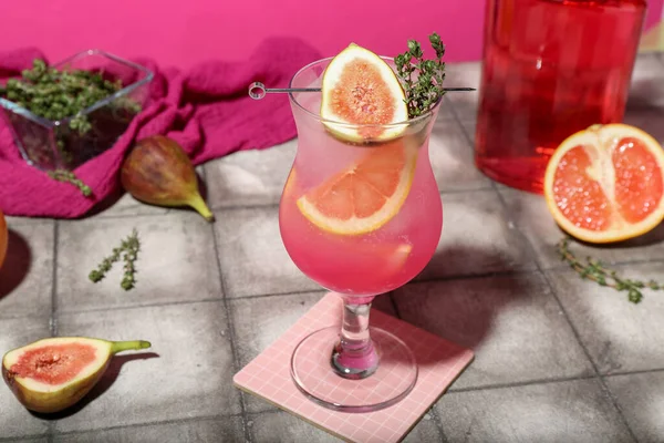 ピンクの壁の近くのタイルテーブルの上にイチジク グレープフルーツとタイムと新鮮な夏のカクテル — ストック写真