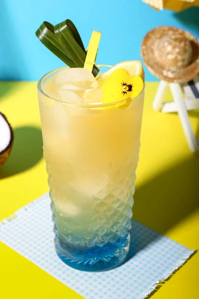 青い壁の近くの黄色のテーブルの上にレモンと花の新鮮な夏のカクテル — ストック写真