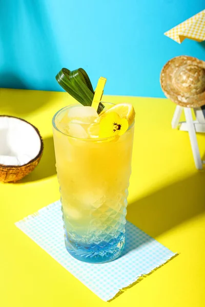 新鲜的夏季鸡尾酒 有柠檬和花 放在蓝色墙边的黄桌上 — 图库照片