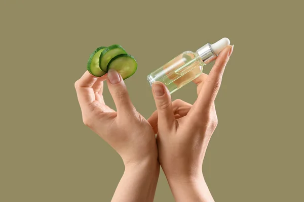 Hands Holding Cosmetic Product Cucumber Slices Color Background — Stock Photo, Image