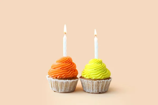 ベージュの背景に誕生日キャンドルとおいしいカップケーキ — ストック写真
