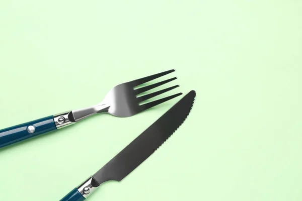 Rostfritt Stål Gaffel Och Kniv Med Plasthandtag Grön Bakgrund — Stockfoto