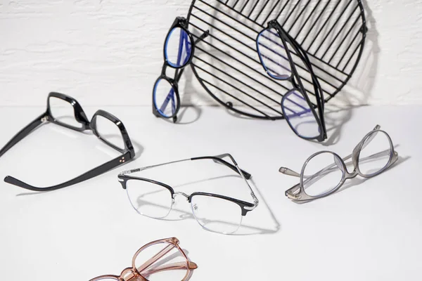 Verschiedene Moderne Brillen Und Stehen Auf Weißem Tisch Wandnähe — Stockfoto