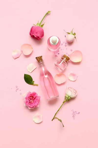 Flaschen Kosmetiköl Mit Rosenextrakt Und Blüten Auf Rosa Hintergrund — Stockfoto