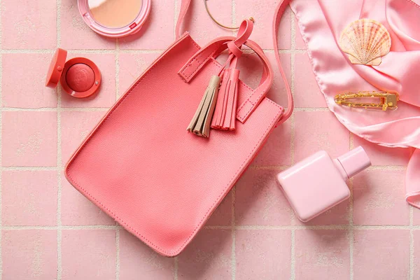 stock image Stylish bag and different accessories on pink tile background